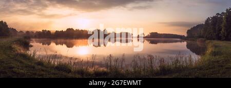 Beautiful sunrise at lake surrounded by forest in Krasnobród, Roztocze, Poland. Stock Photo