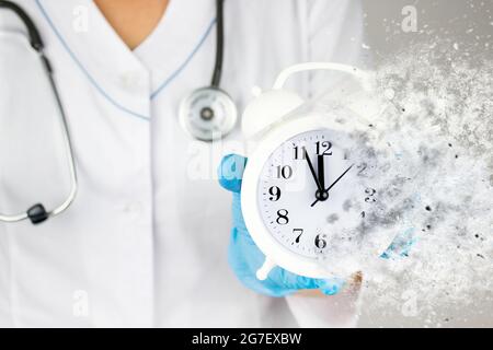 Yearly health check up. Ambulance. Healthcare. Stethoscope and dissolving alarm clock in medical hand. Time is crucial life saver. Health care and pat Stock Photo