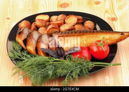 Smoked mackerel on a plate with tomatoes and dill potatoes. Stock Photo
