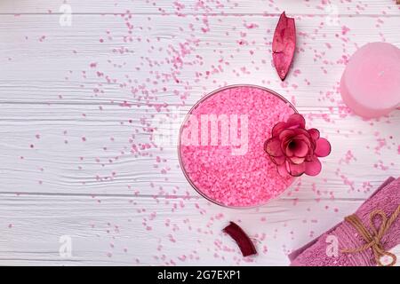 Top view pink sea salt with spa accessories on white wood. Stock Photo