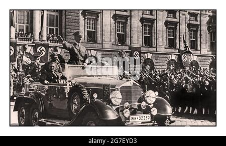 ANSCHLUSS 1938 Austria, Vienna: Adolf Hitler standing in an open top Mercedes car, greets the cheering crowd in Vienna, next to him is the Austrian Chancellor Arthur Seyss-Inquart. On March 12, 1938, soldiers of the German Wehrmnacht crossed the border to the Alpine republic. The 'Anschluss' (occupation) is carried out amid the cheers of hundreds of thousands of Austrians; Austria ceased to exist for seven years. Stock Photo