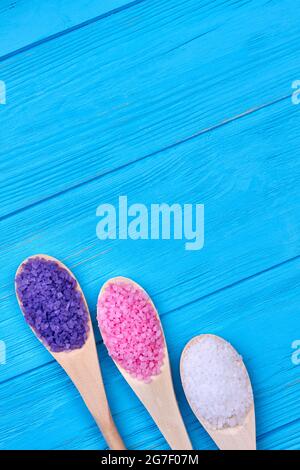 Different types of spa sea salt in wooden spoons flat lay. Stock Photo