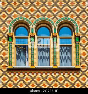 Arched colorful windows on vivid wall with multi colored tiles Stock Photo