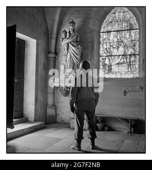 WW2 GI American Soldier pauses to look at a statue of the Madonna and Child in a church, in Italy Europe during World War II  Toni Frissell photographer taken between 1940 and 1945 -  World War, 1939-1945--Religious aspects Churches--Europe--1940-1950, Soldiers--Europe--1940-1950 Stock Photo