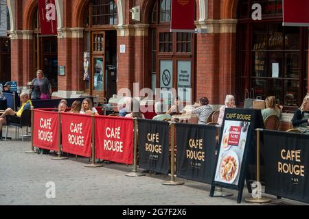 Windsor, Berkshire, UK. 13th July, 2021. People sit outside at Cafe Rouge. Windsor was busy today with shoppers and people eating out. As the Covid-19 lockdown is ending on Monday 19th July, 2021, the town is likely to become much busier as more tourists return. Credit: Maureen McLean/Alamy Stock Photo