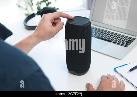 Man using smart speaker. Modern smart home device, intelligent assistant appliance Stock Photo