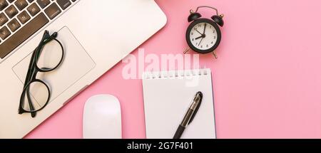 Blank white notepad with office and personal accessories, black alarm clock and glasses, on pink background, business and education motivation and inspiration concept. Stock Photo