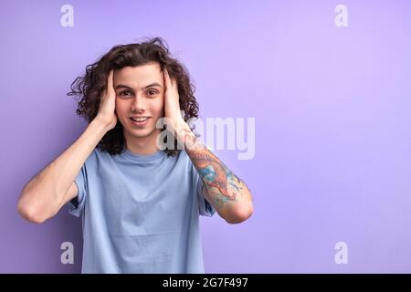 Thoughtful guy touching head, conceived plan, made decision, look at camera with inspired facial expression. isolated purple background, portrait Stock Photo