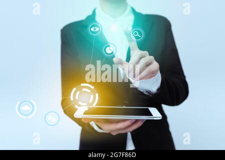 Woman In Uniform Standing Carrying Phone Pointing On Virtual Interface Display Icons. Lady In Suit Holding Mobile Device Points Towards Innovative Stock Photo