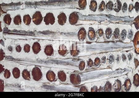 This old log cabin gingerbread house in the woods is intricate and simple. The weathered cord wood walls are shown. Stock Photo