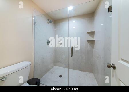 Interior of a bathroom with frameless shower stall Stock Photo