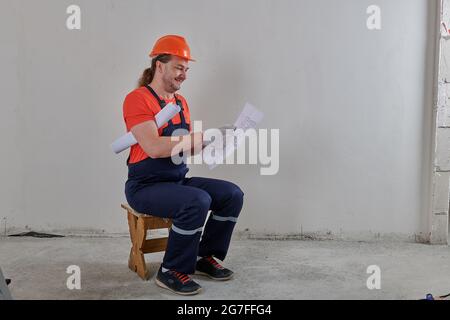 with drawings an engineer sits on a chair Stock Photo