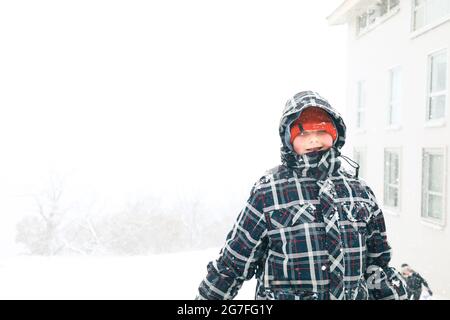 Young boy wearing snow suit during snowstorm at Australian ski resort Stock Photo
