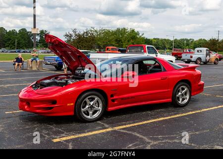 A red 2000 Pontiac Firebird Trans Am coupe on display with the hood open at a car show in Angola, Indiana, USA. Stock Photo