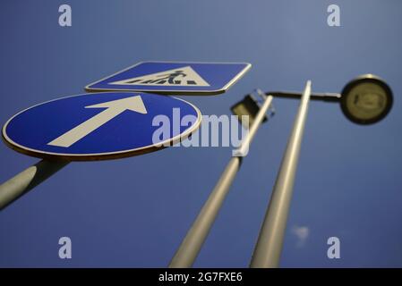 Low angle shot of an up arrow and pedestrian crossing signposts Stock Photo