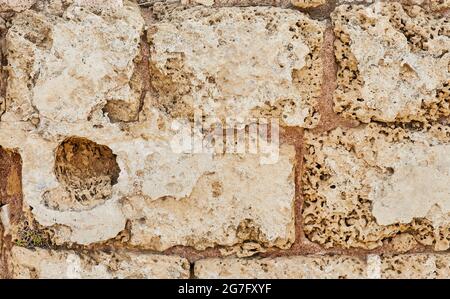 Background of the stone wall of the castle made of stones of different shapes and sizes and textures Stock Photo