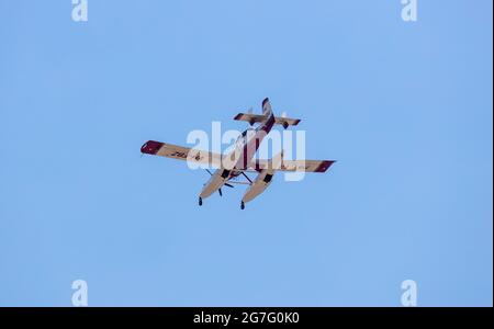Greece, Athens. July 13, 2021. VH FNA Air Tractor  aircraft of the Greek fire brigade, in action to extinguish a fire, blue sky background. Stock Photo