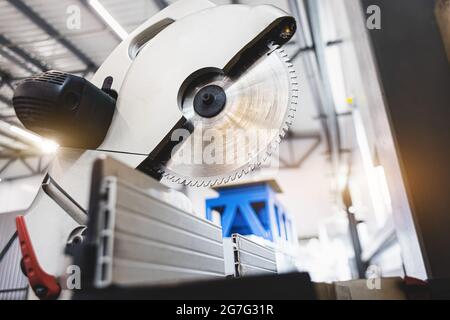 Carpenter cutting flaxboard using sliding compound mitre saw Stock Photo
