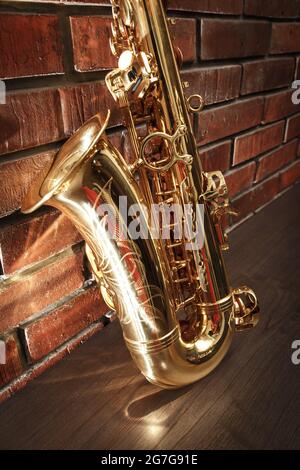 Cropped golden brass saxophone lying on the ground Stock Photo