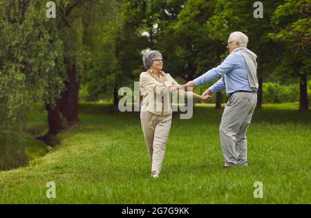 Happy elderly pensioners, man and woman, husband and wife, dancing together Stock Photo
