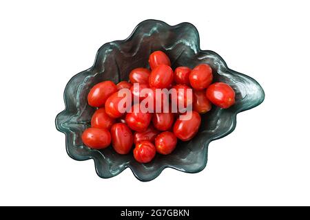 Small red Roma tomatoes in a green glass bowl on a white background Stock Photo