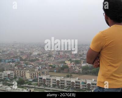 Man looking over City Skyline at Faridabad, Delhi NCR, INDIA Stock Photo