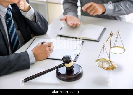 Judge gavel with scales of justice, Businessman and lawyer or counselor consulting and discussing contract papers at law firm in office. Stock Photo