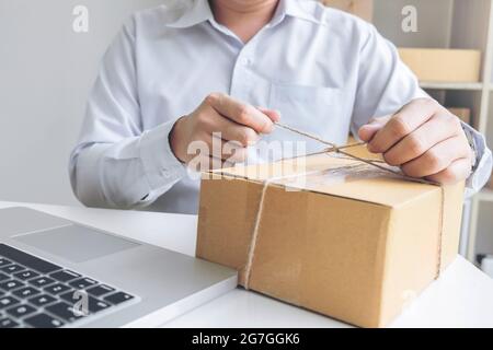 Internet online shopping concept, Young seller man preparing package to be sent Mail transportation, service network connection market, technology on Stock Photo
