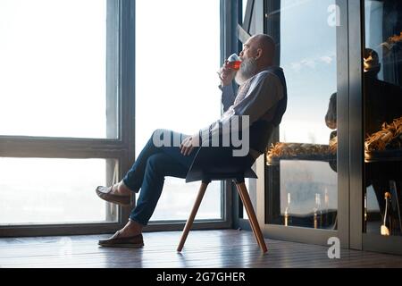 man tasting wine sitting in a wine hall. Stock Photo