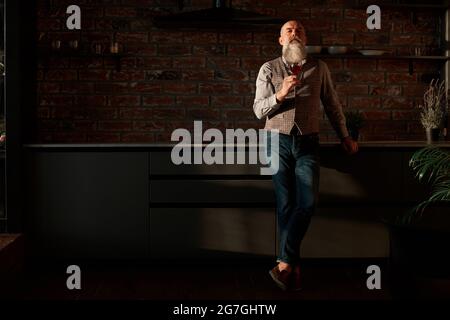 handsome man looking at the red wine in his glass . Stock Photo