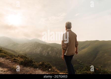 Focused Asian male athlete doing deadlift with heavy barbell during workout in gym Stock Photo