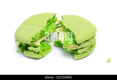 One green macaroon isolated on white background, colorful french cookies macarons. Broken cookie with crumbs Stock Photo