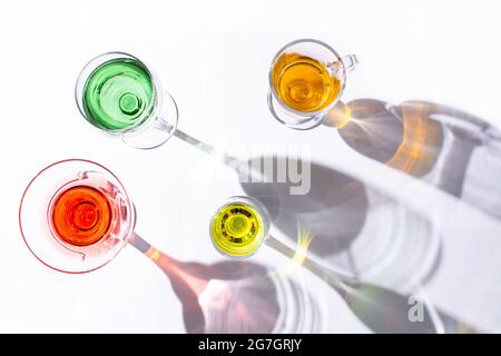 Top view of different types of glasses with colorful liquid inside on white background Stock Photo