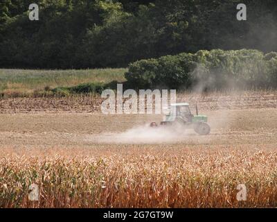 Farmer with his tractor harrowing the field after grain harvest Stock ...