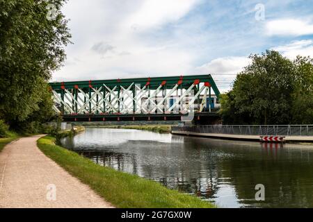 A train crosses the iron railway bridge over the River Cam at Stourbridge Common. Cambridge, UK. Stock Photo