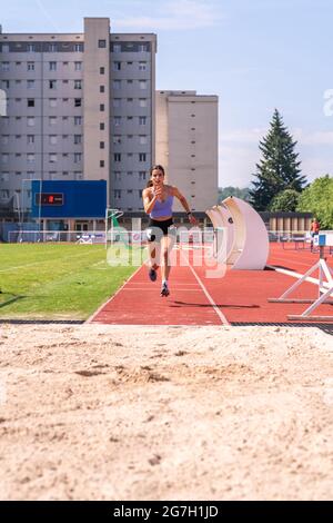 Female track and field athlete long jumping Stock Photo - Alamy