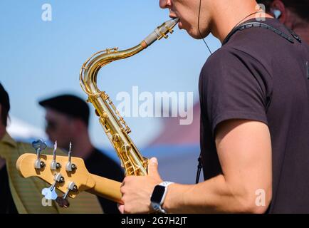Crop man playing saxophone on street Stock Photo