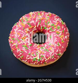 Pink caramel glazed donut on dark minimal background close-up Stock Photo