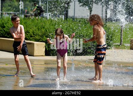 Three children playing in water games and fountains in Quebec City, Canada Stock Photo