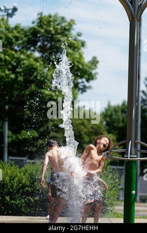 Three children playing in water games and fountains in Quebec City, Canada Stock Photo