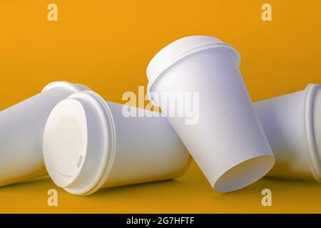 Spilled White Paper Coffee Cups on Green Background, Paper Coffee Cup Template. Stock Photo
