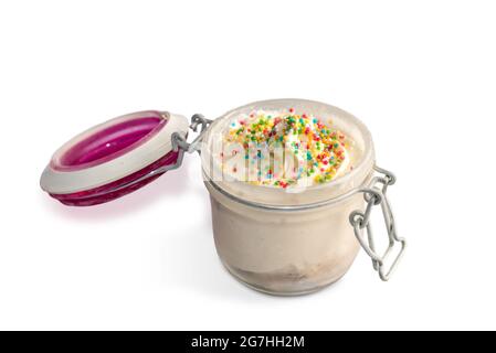 Milk ice cream with colorful sugar beads served in open Glass Jar. Isolated on white Stock Photo