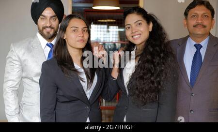 Group of Indian co-workers wearing suits in office Stock Photo