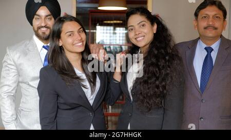 Group of Indian co-workers wearing suits in office Stock Photo