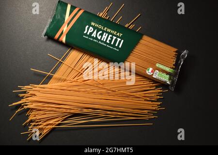 Wholewheat Spaghetti on dark background Stock Photo