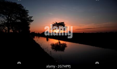 Beautiful, Sunset behind the trees, reflection and rivers in Jember Indonesia Stock Photo