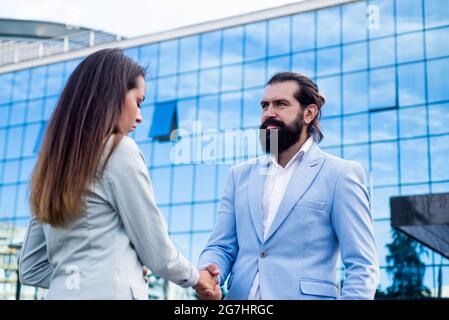 business couple shaking hands. bearded man meet woman outdoor. business meeting. Stock Photo