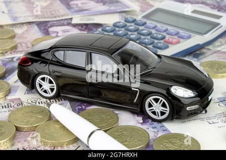 A car finance metaphor with a luxury car, calculator and cash. Stock Photo