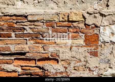 old brick and stucco wall, with deteriorating brick and mortar Stock Photo