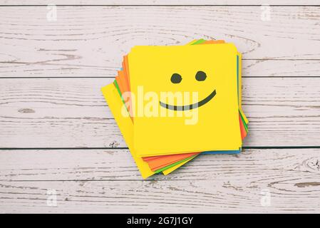 Happy emoticon on yellow paper note Stock Photo